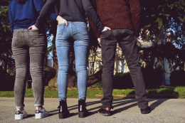 Three people from the back keeping their hands in each other's back pockets
